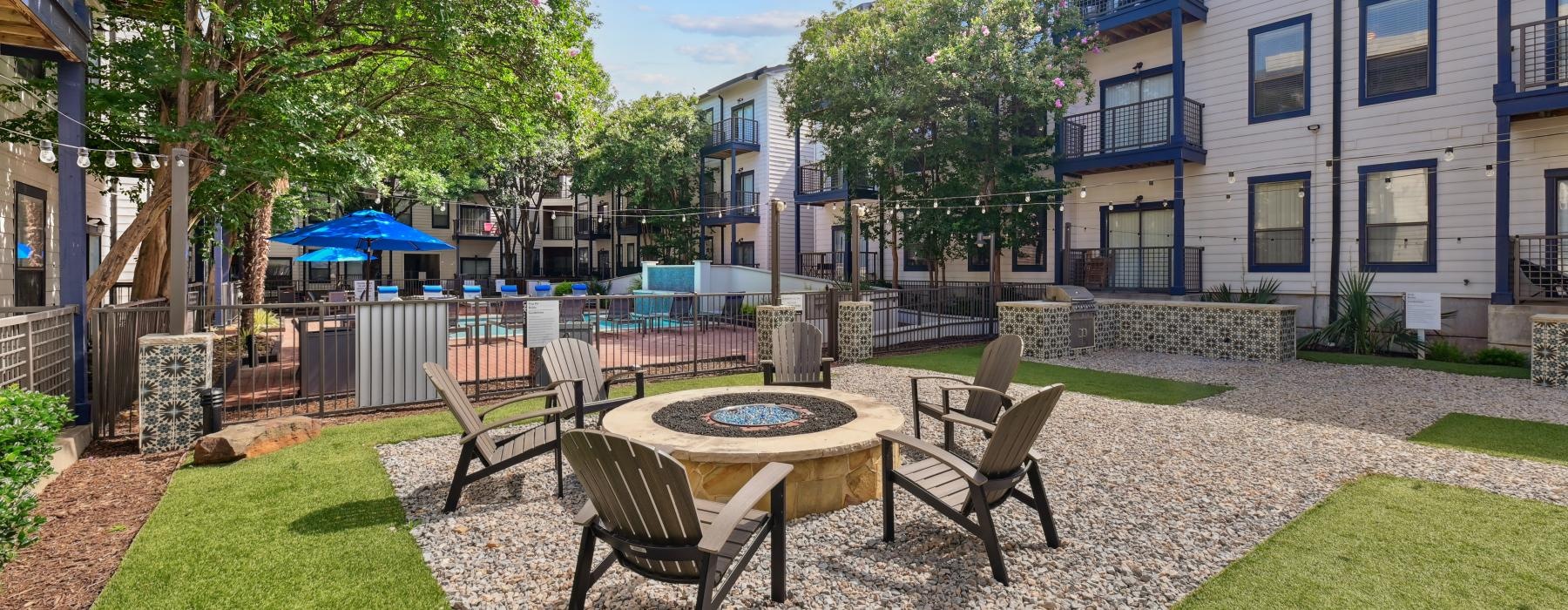 a courtyard with chairs and a firepit